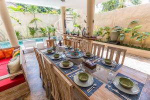 a dining room with a long wooden table and chairs at Villa Josefine, 5 Bedroom pool, rooftop, pool table in Seminyak
