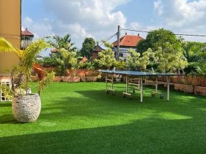 a green lawn with a ping pong table on it at Villa Josefine, 5 Bedroom pool, rooftop, pool table in Seminyak