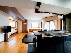 une cuisine avec un évier et un salon dans l'établissement The LAMP Minoshima, à Sumiyoshi
