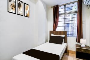 een kleine slaapkamer met een bed en een raam bij Super COLLECTION O SIXMILE GUWAHATI FORMERLY HOTEL GANGOTRI in Guwahati +26 foto's