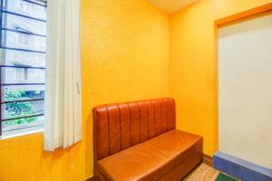 een bruine leren stoel in een kamer met een raam bij Super COLLECTION O SIXMILE GUWAHATI FORMERLY HOTEL GANGOTRI in Guwahati