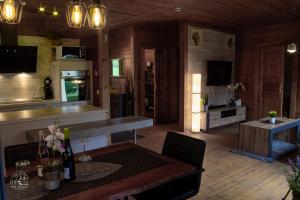 a kitchen and living room with a table and a counter at Holzblockhaus, Eifel in Oberkail