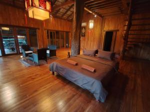 une chambre avec un grand lit et un parquet dans l'établissement Nirvana Archipel Resort, à Vang Vieng