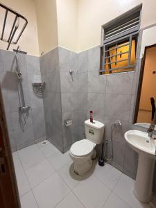 a bathroom with a toilet and a sink at Makindye Orange House in Kampala +29 photos