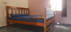 - une chambre avec des lits superposés en bois et des draps bleus dans l'établissement Vjay Shakti Homestay, à Gokarna