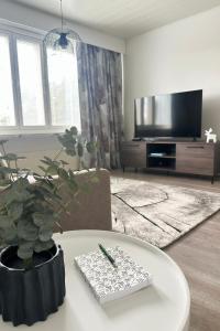 a living room with a table with a plant and a tv at Kaksio hyvällä sijainnilla in Kemijärvi