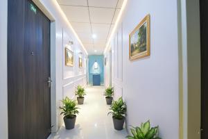 a corridor with potted plants in a hallway at Via Alpha in Gurgaon