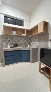 a kitchen with blue cabinets and a tile wall at StudioMimi Near UTP UiTM Seri Iskandar in Seri Iskandar