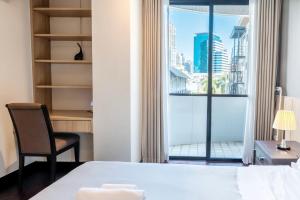 a bedroom with a window with a view of a city at Taweewan Place Bangkok in Bangkok