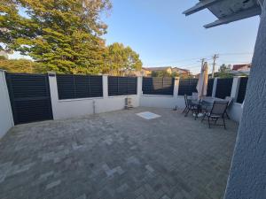 Un patio con sillas y una mesa y una valla. en Apartament Parc 1A, en Ploieşti