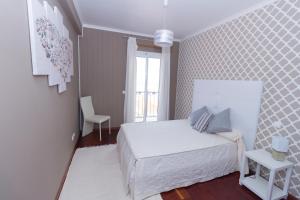 A bed or beds in a room at Oliveira's Apartments - Madeira Island