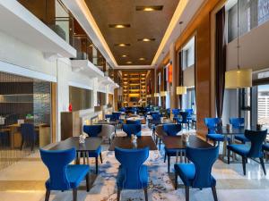 a restaurant with blue chairs and tables at Swissôtel Grand Shanghai - Stroll down West Nanjing Road and soak in downtown Shanghai vibrancy in Shanghai