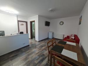 Una sala de estar con una mesa y una cocina. en Apartament Parc 1B, en Ploieşti
