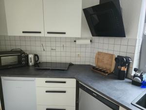 una cocina con encimera y microondas en Smartes City Apartment - Top Location!, en Halle an der Saale 3 fotos más