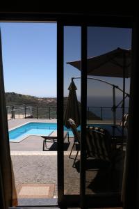 a patio with a hammock and a swimming pool at Casa da Caixeira in Arco da Calheta