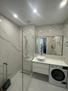 een badkamer met wastafel en wasmachine bij Apartments on Plekhanovo in Tbilisi City
