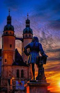 una estatua de una persona frente a un castillo en Smartes City Apartment - Top Location!, en Halle an der Saale