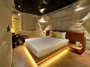 胡志明市Cupid Hotel 3的一间卧室，石墙内有一张床