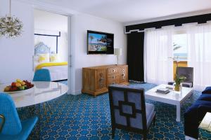 a living room with a bed and a living room with a room at Eau Palm Beach Resort & Spa in Palm Beach