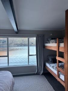 ein Schlafzimmer mit Etagenbetten und einem großen Fenster in der Unterkunft Lake Oasis in Queenstown