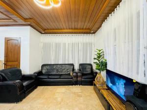 a living room with black leather furniture and a fish tank at Matthews Home Cebu-Casa Dos in Cebu City