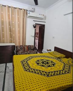 two beds in a room with a yellow blanket on them at Hotel nitin in McLeod Ganj
