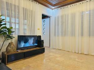a television sitting in a living room with curtains at Matthews Home Cebu-Casa Dos in Cebu City