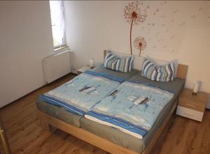 a bedroom with a bed with a blue comforter at zum Schilfrohr in Neuendorf