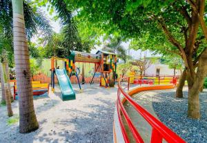 een speeltuin met een glijbaan in een park met bomen bij The Stayhaus by Dan & Steph in Manilla