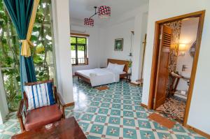 a room with a bed and a table and chairs at Hotel De Condor in Con Dao