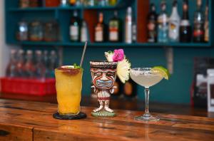 Zwei Cocktails stehen auf einem Holztisch in einer Bar. in der Unterkunft Hotel De Condor in Con Dao + 80 Fotos
