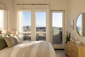 a bedroom with a bed and a mirror and windows at Avelle in Mountain View