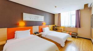 pokój hotelowy z dwoma łóżkami i oknem w obiekcie IU Hotel Tianjin Youyi Road Meijiang Exhibition Meiniu Metro Station w mieście Tiencin