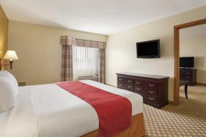 a hotel room with a bed and a television at Country Inn & Suites by Radisson, Lincoln North Hotel and Conference Center, NE in Lincoln