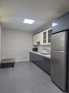 a kitchen with a stainless steel refrigerator and cabinets at Taebaek The Palace Hotel in Taebaek