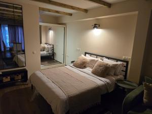Un dormitorio con una cama con un espejo grande. en Studio in old town tbilisi, en Tiflis