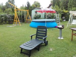a playground with a bench and an umbrella in a yard at János Nyaraló in Balatonmáriafürdő