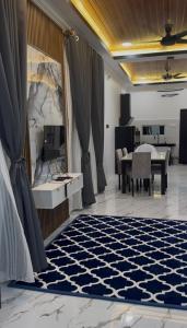 a living room with a table and a blue and white rug at Ali Homestay Jeli in Jeli