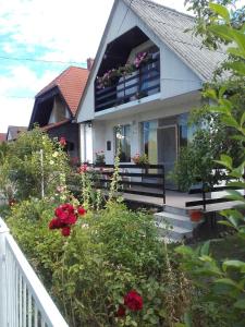 una casa con un balcón con flores. en János Nyaraló en Balatonmáriafürdő