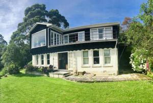 a large house with a green lawn in front of it at Lear House Oamaru in Motungarara