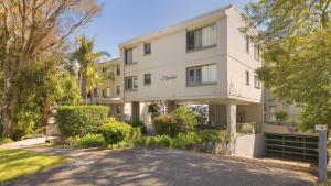 a large white building with trees and a driveway at The Poplars Apartment Nelson Bay with Swimming Pool in Nelson Bay