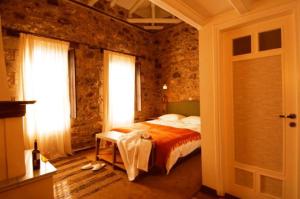 1 dormitorio con cama y pared de ladrillo en Guesthouse Theonimfi, en Dhimitsana