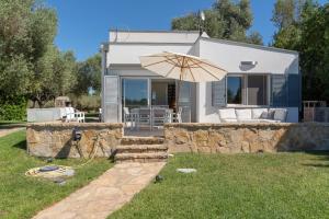 una casa con un muro di pietra e un ombrello di Villa Rucchetta a Casa Linari