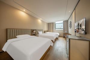 a hotel room with three beds and a flat screen tv at 沁住酒店重庆南坪万达广场店 in Chongqing +18 photos