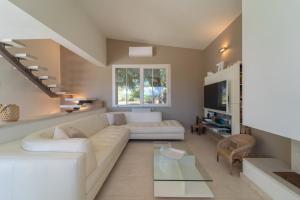 un soggiorno con divano bianco e tavolo in vetro di Villa Rucchetta a Casa Linari