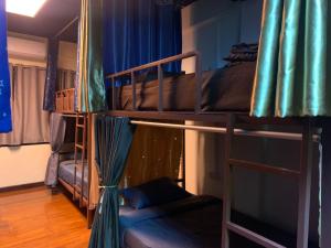 two bunk beds in a room with a couch at Roxx Social Hostel, Cafe & Bistro in Bangkok +95 photos