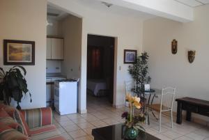 a kitchen and a living room with a couch and a table at Apart Hotel Valle Verde in San Salvador