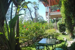 a table and chairs in a garden with a balcony at Apart Hotel Valle Verde in San Salvador
