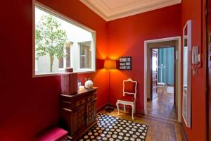 a red room with a window and a desk and a chair at Apartamento Porto Baixa in Porto