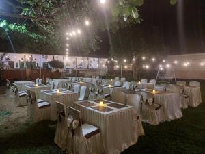 a group of tables with white chairs and lights at Siuri Cottages & Restaurant in Tokaimbu